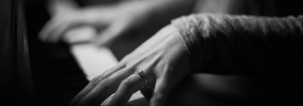 closeup of hands playing a piano